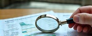 Magnifying glass over a sustainability report, indicating third-party verification